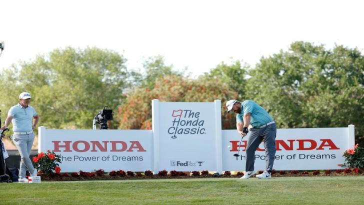 Matt Jones looks on as JB Holmes tees off at the Honda Classic